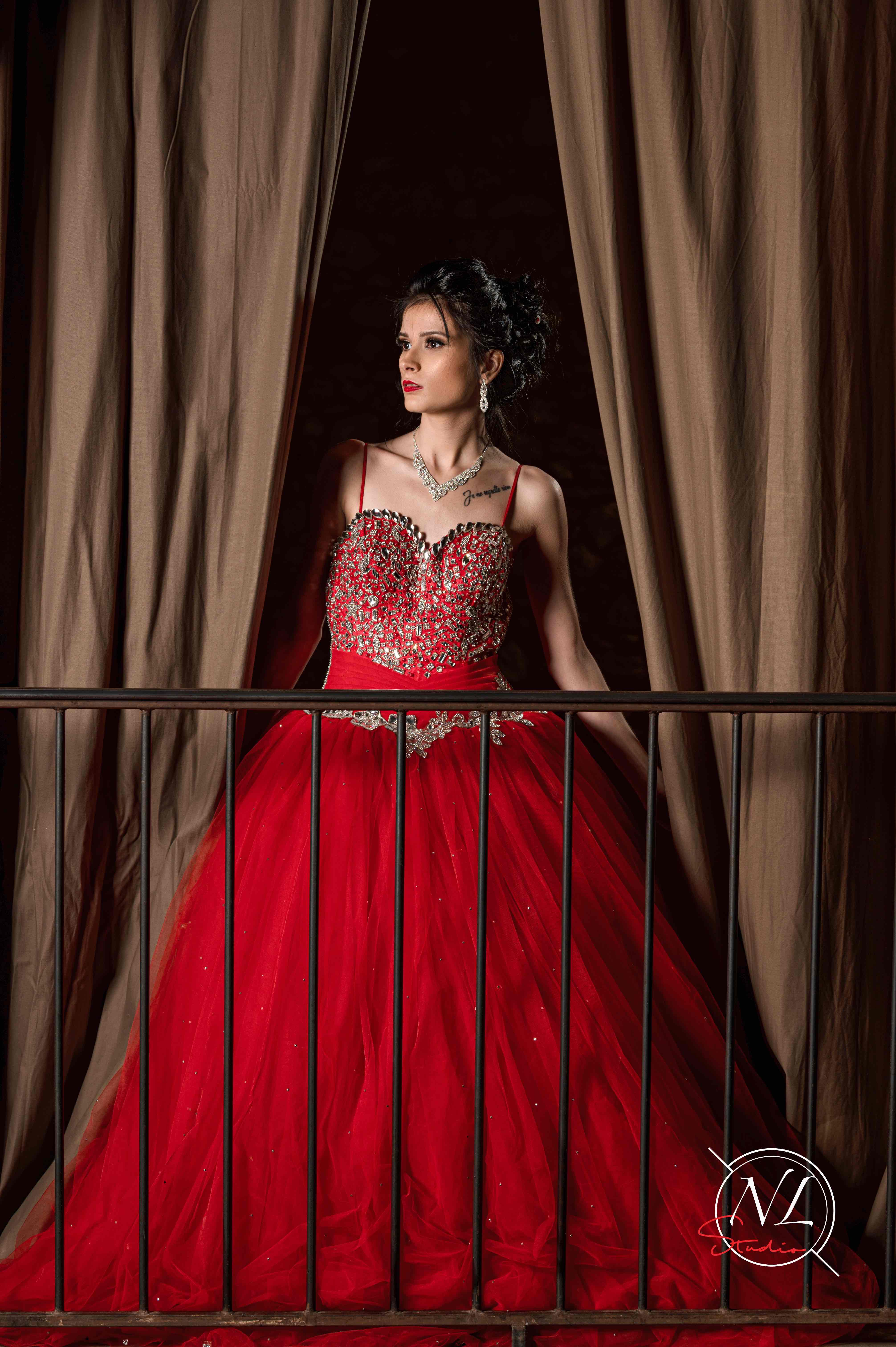 Photo de mode à Agen : robe rouge élégante sur balcon